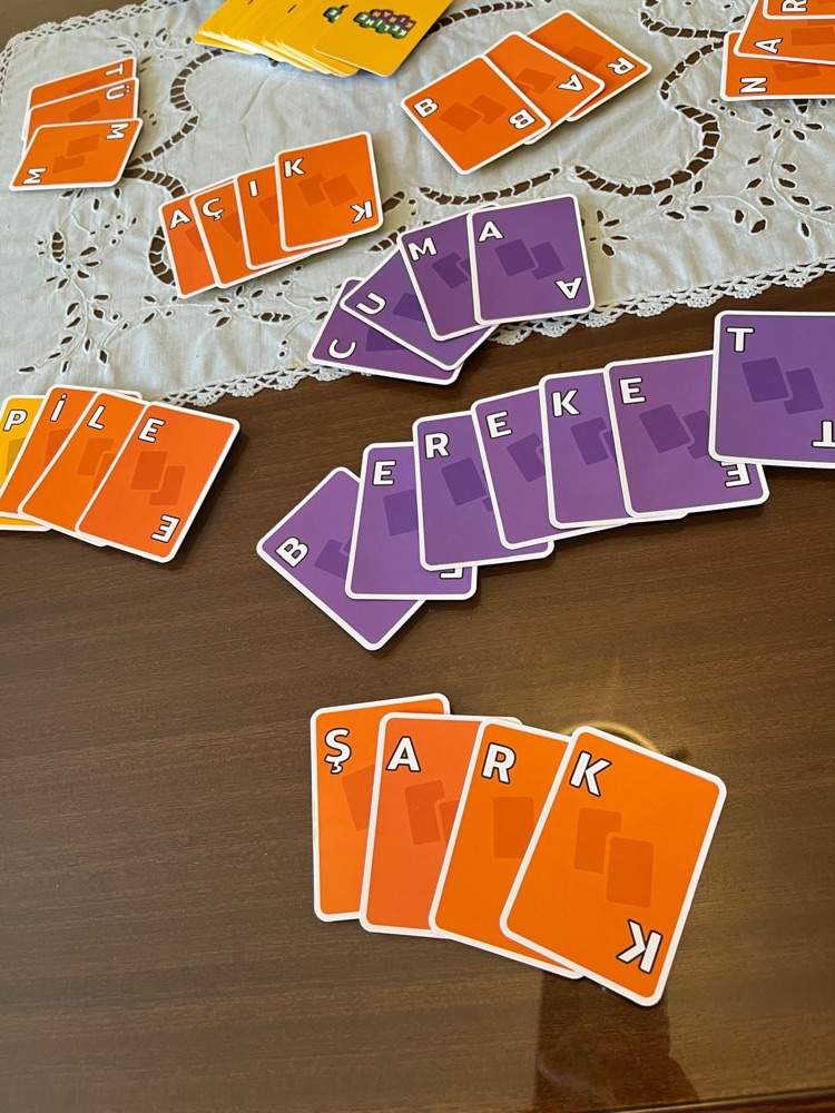 Words laid out in Kelime Kıran cards on a wooden table
